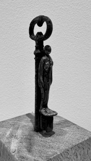 Mixed Media Objekte, Kunst, Eisenschlüssel mit Keramikfigur auf Holzsockel. Die kleinen gebrannten Figuren schimmern bronzefarbig.